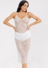 Vestido midi de tirantes finos, confeccionado en tejido de red semitransparente con lentejuelas blancas brillantes. Presenta un diseño ajustado con forro integrado en la zona del torso y la cadera.