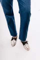 Mocasín de estilo náutico confeccionado en cuero gamuzado color tostado, con cordones decorativos laterales y en el empeine.