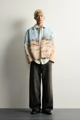 Cazadora relaxed fit de tejido jacquard ligeramente acolchado, con estampado de paisaje costero y texto "Un dernier souffle d'été". Cuenta con cuello solapa con inscripción, manga larga, bolsillos de vivo en la cadera y cierre frontal con cremallera.