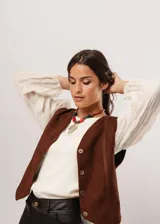 Blusa color manteca de cuello redondo y mangas largas abullonadas con puños elásticos.