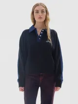 Buzo de friza suave color azul marino, con cuello polo y cartera de botones en contraste azul denim. Mangas raglán con franjas laterales azules y logo bordado en el pecho.