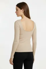 Remera de manga larga confeccionada en algodón, con diseño al cuerpo, cuello bote y abertura en la espalda.