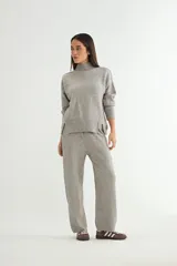 Conjunto de dos piezas compuesto por un sweater de cuello alto con aberturas laterales en el ruedo y un pantalón de corte recto y holgado, ambos confeccionados en tejido de punto suave.