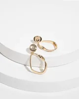 Aros colgantes dorados con forma irregular y detalle de strass.