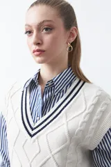 Chaleco de punto color bordó, con diseño de rombos y trenzas en relieve. Escote en V con ribete blanco y rojo.