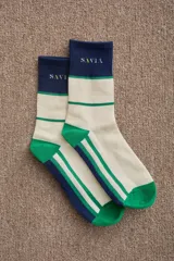 Medias de caña media con diseño tricolor en blanco, verde y azul marino. Presentan el logo de la marca bordado en la parte superior y puntera y talón reforzados en color verde.