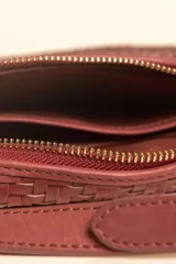 Bandolera de gamuza color marrón con diseño de media luna, decorada con tachas metálicas doradas distribuidas en el frente. Cuenta con cierre superior metálico y correa larga ajustable para llevar cruzada.