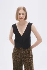 Top tipo chaleco de corte entallado, con escote en V y cierre frontal con botones a tono.