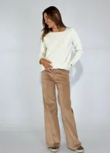 Pantalón de corte recto y tiro medio, confeccionado en pana color bordó. Presenta costuras verticales decorativas en el frente, cierre con botón y bolsillos laterales.