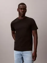 Remera de algodón negro con cuello redondo, manga corta, corte clásico y sutil monograma bordado en el pecho.