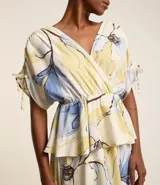 Vestido evasê midi de viscolino con estampado floral, escote en V cruzado, mangas cortas con lazos y corte en la cintura.