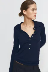 Jersey polo de punto fino color verde lima, confeccionado con lana. Presenta cuello polo, manga larga y botones delanteros.