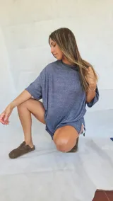 Remera oversize gris melange de manga corta y corte amplio, con aberturas laterales en el dobladillo.