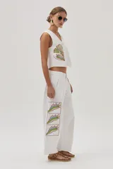 Chaleco blanco de gabardina con bordados florales y cierre frontal con botones forrados en la misma tela.