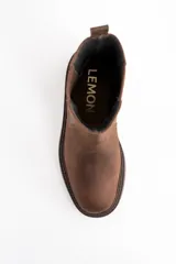 Bota tipo Chelsea de caña media, confeccionada en cuero legítimo color marrón con acabado mate. Presenta paneles laterales elásticos al tono y una suela de goma robusta con plataforma baja.