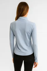 Campera deportiva de cuello alto con cierre frontal completo, manga larga y bolsillos laterales integrados. Diseño entallado al cuerpo.