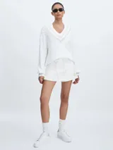 Short pollera blanco de algodón orgánico tejido con cintura con cordón y logo TU bordado en dorado en la parte delantera.