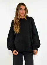 Sweater de tejido de punto color negro, con cuello redondo, mangas largas con puños ajustados y diseño holgado.