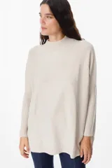 Sweater crudo de punto con cuello alto y mangas largas con puños ajustados.