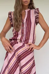 Blusa sin mangas a rayas en tonos rosado y bordó con hilos dorados, escote en V con botones frontales y volados en los hombros.