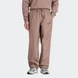 Pantalón deportivo New Balance de tejido técnico color marrón topo, con cintura elástica ajustable con cordón, bolsillos laterales con cierre y cordón de ajuste en el dobladillo. Presenta un pequeño logo gráfico en la pierna izquierda.