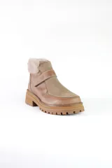 Bota corta de cuero marrón con puntera de gamuza, cuello de piel sintética negra, cierre con velcro y suela track negra.