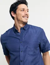 Camisa azul con estampado de lunares blancos, de manga corta y corte clásico.