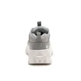Sneaker Caterpillar modelo Intruder Lite, color gris con suela chunky blanca. Presenta un diseño robusto con paneles de gamuza y cuero sintético, cordones blancos y logo de la marca en el lateral.