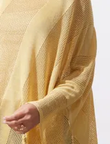 Poncho de tejido calado con acabado brillante, diseño asimétrico y cuello redondo.
