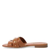 Sandalias tipo zueco de cuero color suela, con puntera cuadrada, suela plana y detalle de tachas metálicas doradas en la tira superior.