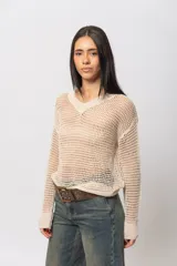 Sweater calado color beige de hilo con escote en V, mangas largas y silueta relaxed.