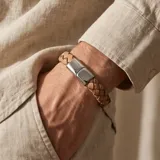 Pulsera de diseño trenzado en color marrón claro, con cierre magnético de acero inoxidable pulido.