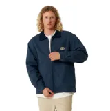 Campera azul marino con cuello de pana, cierre frontal, puños abotonados y elástico en la cintura. Tiene un parche ovalado con el logo de la marca en el pecho.