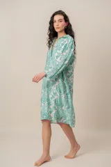 Vestido midi verde con estampado de arabescos, cuello camisero con escote en V y cierre frontal parcial de botones, de manga corta y corte recto.