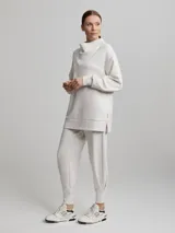 Sweater jogger largo color crema con cuello tortuga.