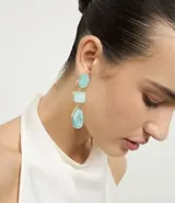 Aros colgantes con tres formas geométricas de resina color celeste y engarce dorado. Cierre a rosca.