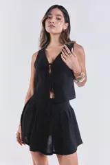 Chaleco negro con escote en V y lazo de ajuste frontal.