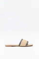 Sandalias planas con capellada ancha de tejido trenzado en color beige con detalles en negro.