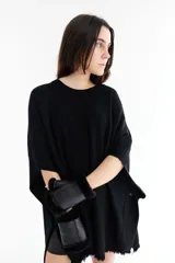 Poncho celeste de tejido de punto con cuello redondo y terminación desflecada.