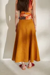Pollera larga azul de tiro alto, con botonadura frontal y aberturas en el bajo.