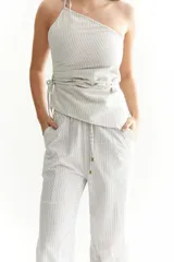 Top blanco con rayas verticales rojas, de un solo hombro y con lazo para ajustar en la cintura.