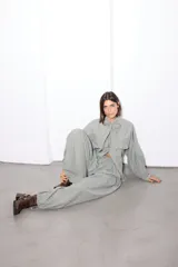 Pantalon de corte amplio con diseño a cuadros en tonos gris, blanco y naranja. Presenta cintura elástica con cordón ajustable y detalle de tiras en la botamanga para fruncir.
