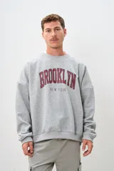Buzo gris con estampa en el frente con el texto "Brooklyn New York" en color bordó.