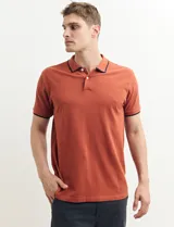 Remera polo azul marino con ribetes blancos en el cuello y en los bordes de las mangas corta, y cierre frontal de botones.