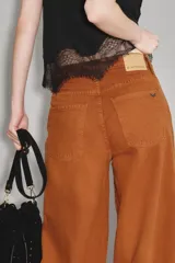 Pantalón de jean corte oxford, color camel, con tiro medio y diseño de pierna ancha. Presenta costuras reforzadas y bolsillos traseros clásicos.