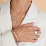 Collar de plata 925 con cadena fina de eslabones y dije circular con diseño trenzado.