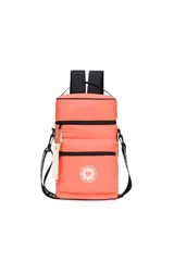 Mochila acolchada color coral/naranja, con dos compartimentos principales con cierre y correas negras. Incluye un llavero colgante con la palabra "TRENDY" y un parche circular con un corazón.