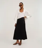 Pollera larga negra de corte evasé, confeccionada en satén, con recortes de pences que le dan volumen.