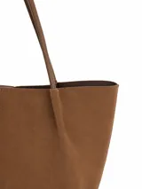 Cartera tipo shopper de gamuza color marrón, con diseño minimalista, formato amplio y asas largas para llevar al hombro.