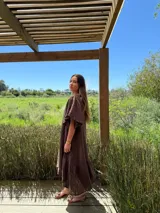 Vestido verde oliva de lino, corte suelto, con mangas abullonadas y volado en el ruedo.